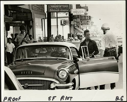 Police officer talking to a man during the 1966 Bayview-Hunters Point riots on Third Street at Palou Avenue AAK-1658.jpg