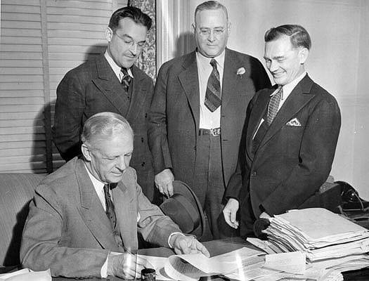Governor-Culbert-Olson-signing-papers-which-opened-the-prison-gates-for-Warren-K-Billings-Oct-1939-AAA-5491.jpg