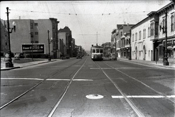 File:25th and Valencia streets looking south at southbound -9 line car and Southern Pacific crossing containing original cable car slot 1942 aax-0116.jpg