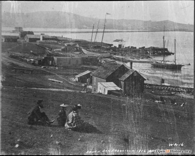 File:South San Francisco 1866 Long Bridge WA-16 View north towards Long Bridge from Hunters Point towards Point San Quentin-Mission Bay Houses, berthed boats; man, woman and child sitting F810 WA-016 GGNRA-Behrman GOGA 35346 wnp71.2239.jpg