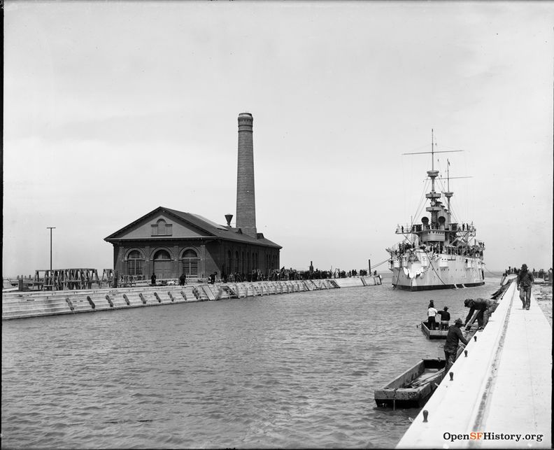 Hunters Point slip c 1900 Battleship entering slip. Pumphouse with tall smokestack at end of pier. G810 SH-592 GGNRA-Behrman GOGA 35346 wnp71.0345.jpg