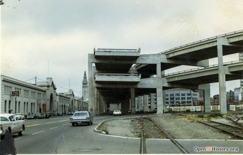C1965 Embarcadero Freeway end, with off ramp curving to Broadway. Ferry Building in distance. Pier Seven Cocktails sign, belt line rails wnp27.6035.jpg