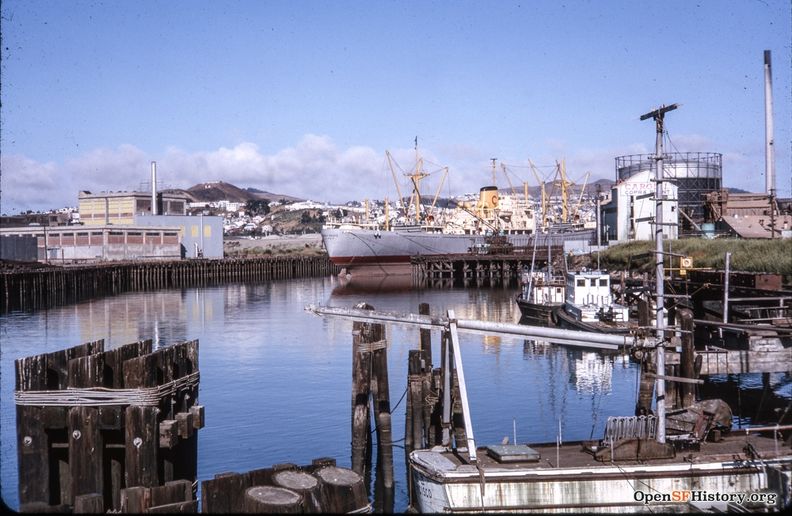 July 1963 Islais Creek View west from 3rd Street Bridge. Ship docked at Cargill Copra Plant, Bernal Heights in background left, Twin Peaks in background right wnp25.1676.jpg