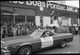 Gay Freedom Day Trophy-bearing individual on hay bale in automobile during Gay Freedom Day parade. Sign reads- Mama Peck of the Roadrunner- Miss Cowgirl 74-75, Duchess of OFarrell St. Bill, Mayor of Central City wnp72.103.jpg